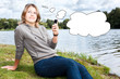 Photo: Young thinking woman with cellphone and blank thought cloud Young thinking woman with cellphone and blank thought cloud