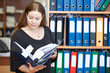 Business woman looking at documents in folder at office