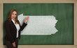 Teacher showing map of pennsylvania on blackboard