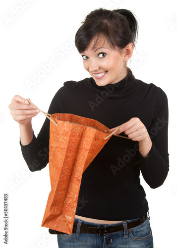 Photo: young woman with curiosity looking to present bag young woman with curiosity looking to present bag