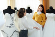  saleswoman helps girl chooses  bridal outfit