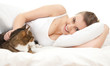 smiling teenage girl with cat relaxing in white bedding