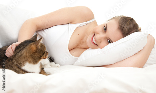 Photo: smiling teenage girl with cat relaxing in white bedding smiling teenage girl with cat relaxing in white bedding