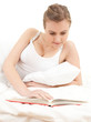 student girln reading book in white bedding