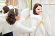 Foto: woman with girl chooses white fur cape at shop woman with girl chooses white fur cape at shop