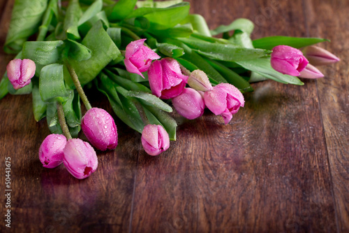 Photo: Pink tulips on a wooden background Pink tulips on a wooden background