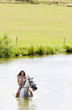 Photo: equestrian on horseback riding through water equestrian on horseback riding through water