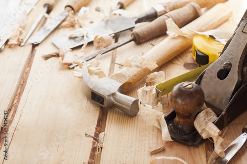 Photo: carpenter tools,hammer,meter,nails and chisel over wood table carpenter tools,hammer,meter,nails and chisel over wood table