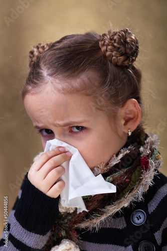 Photo: Little girl in flu season - blowing nose Little girl in flu season - blowing nose