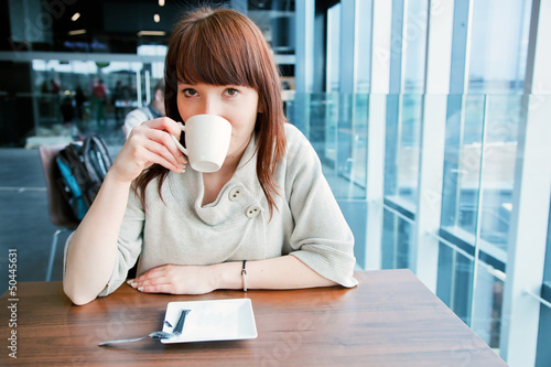 Photo: Woman drinking coffee at a corporate restaurant Woman drinking coffee at a corporate restaurant