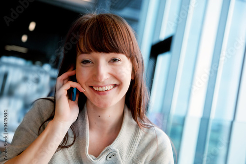 Photo: Beautiful business woman talking on mobile phone and smiling Beautiful business woman talking on mobile phone and smiling
