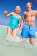 Photo: Senior Couple Having Fun In Sea On Beach Holiday Senior Couple Having Fun In Sea On Beach Holiday