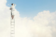 Businesswoman standing on ladder