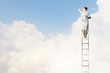 Businesswoman standing on ladder