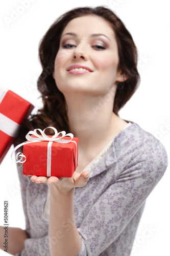 Photo: Young woman demonstrates a gift wrapped in red paper Young woman demonstrates a gift wrapped in red paper