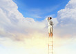 Businesswoman standing on ladder