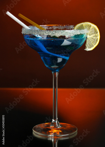 Photo: Yellow cocktail in glass on color background Yellow cocktail in glass on color background