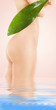 female torso with green leaf over beige background