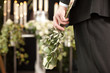 Foto: Grief - man with white roses at urn funeral Grief - man with white roses at urn funeral