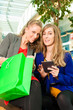 Two women shopping with bags in mall