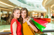 Two women shopping with bags in mall