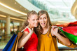 Two women shopping with bags in mall