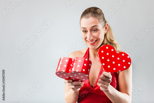 Photo: Woman opening the gift and is happy Woman opening the gift and is happy