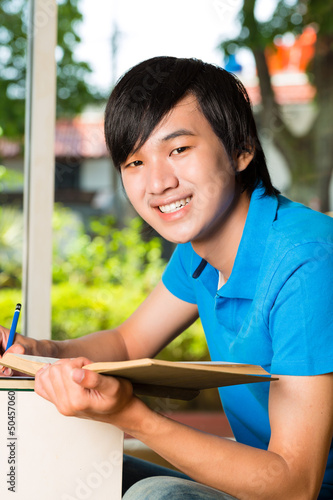 Photo: Asian student reading book or textbook learning Asian student reading book or textbook learning