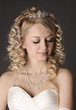 Foto: Young woman dressed as a bride on a gray. Young woman dressed as a bride on a gray.