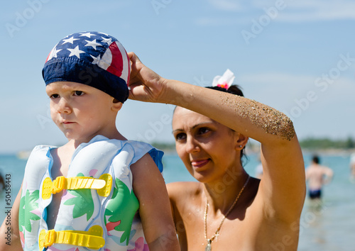 Photo: Mother fastening her sons swimming cap Mother fastening her sons swimming cap