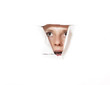 Foto: Young woman looking through torn paper hole Young woman looking through torn paper hole