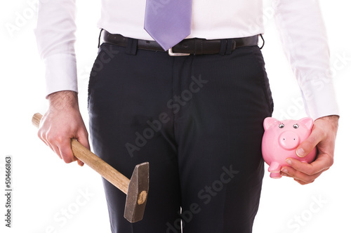 Photo: Businessman with piggy bank and hammer. Businessman with piggy bank and hammer.