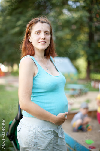 Photo: pregnancy woman against playground area pregnancy woman against playground area