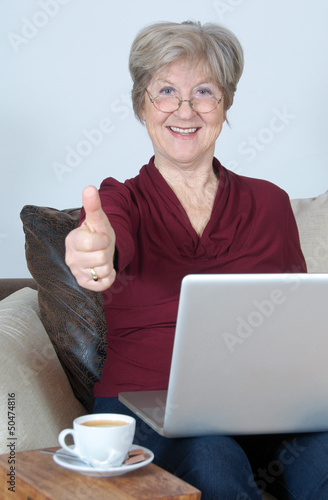 Photo: Seniorin mit Computer – Daumen hoch Seniorin mit Computer – Daumen hoch