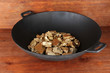 Gold pan with golden nuggets inside on wooden background