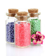 Little bottles full with colorful beads isolated on white