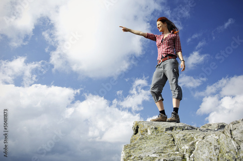 Photo: Woman standing on a mountain and gazing in the distance Woman standing on a mountain and gazing in the distance