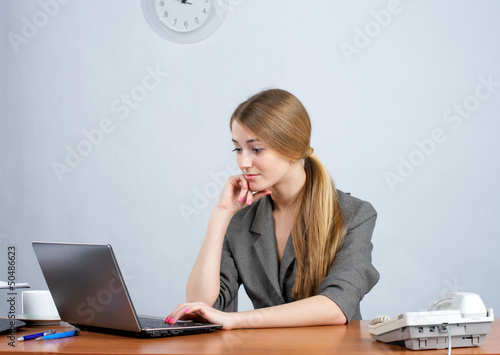 Photo: Young female executive working on laptop Young female executive working on laptop