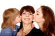 Two daughters kissing mother. Motherhood concept.