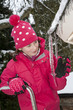 Winter cold snap. Young girl measures icicle depth