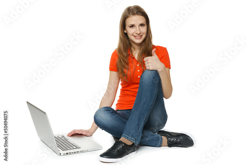 Photo: Woman sitting on floor with laptop making thumb up Woman sitting on floor with laptop making thumb up