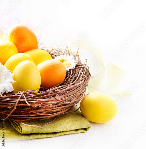 Photo: Easter. Painted Easter Eggs and Spring Flowers in the Nest Easter. Painted Easter Eggs and Spring Flowers in the Nest