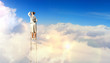 Businesswoman standing on ladder