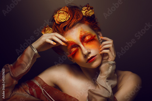 Photo: Bodyart. Artistic Woman. Red - Gold Makeup and Flowers. Coloring Bodyart. Artistic Woman. Red - Gold Makeup and Flowers. Coloring