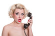 Shocked blond beauty on vintage telephone  - isolated on white