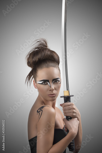 Photo: brunette in japan style with katana looka in to the lens brunette in japan style with katana looka in to the lens