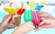 Cocktails in hands on pool background