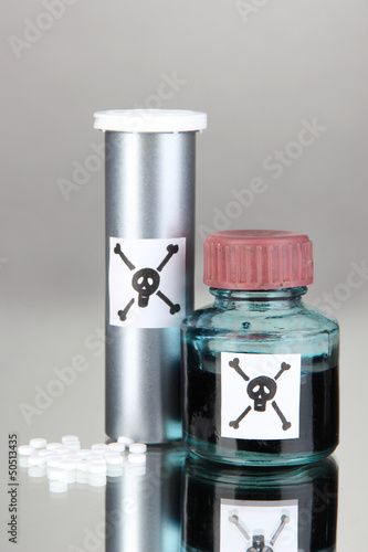 Photo: Deadly poison in bottles on grey background Deadly poison in bottles on grey background