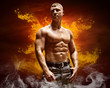 Bodybuilder posing on the fire flames background