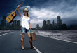 Young woman with guitar on the road and her vintage baggage